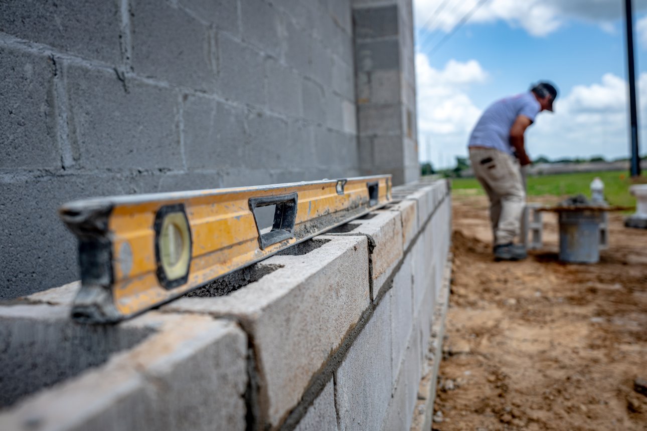 Mason Using Level on CMU Monument Sign