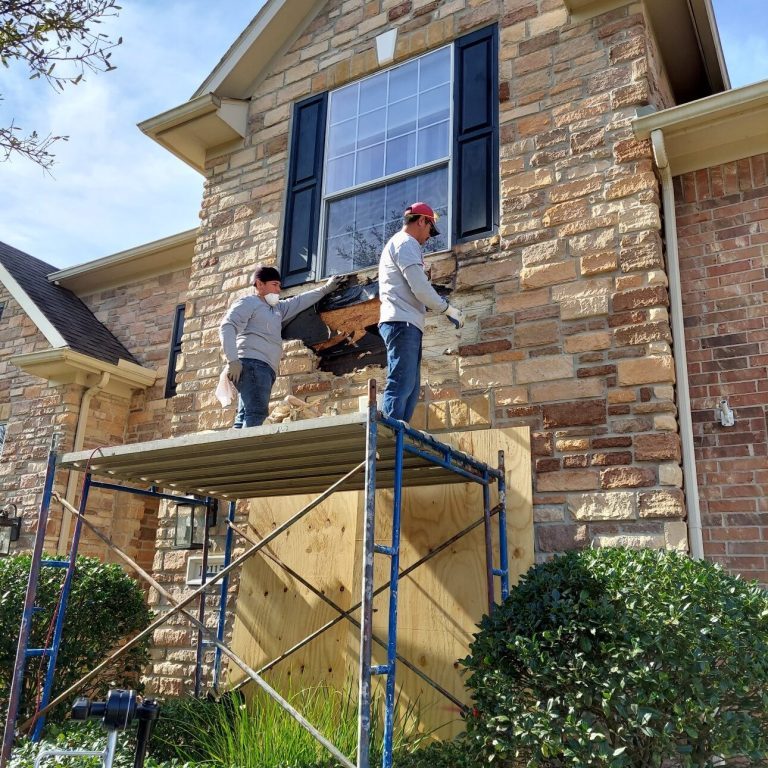 Masons Repairing Loose Stones on Home